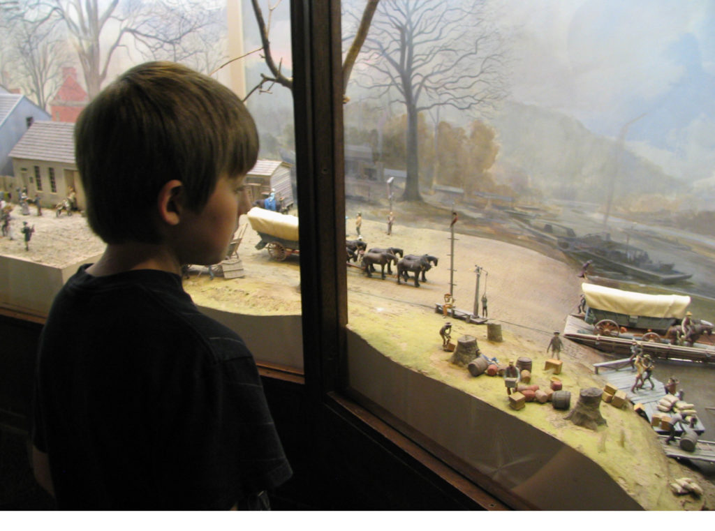 Boy looking at window display at National Road museum